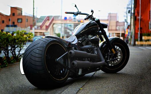 Обои на рабочий стол Черный мотоцикл Harley Davidson стоит на городской дороге