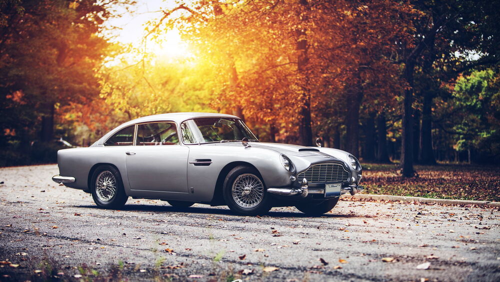 Обои для рабочего стола Серый Aston Martin DB5 на осенней дороге