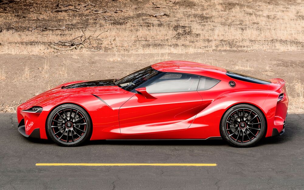 Обои для рабочего стола Красная Toyota Supra на горной дороге сбоку