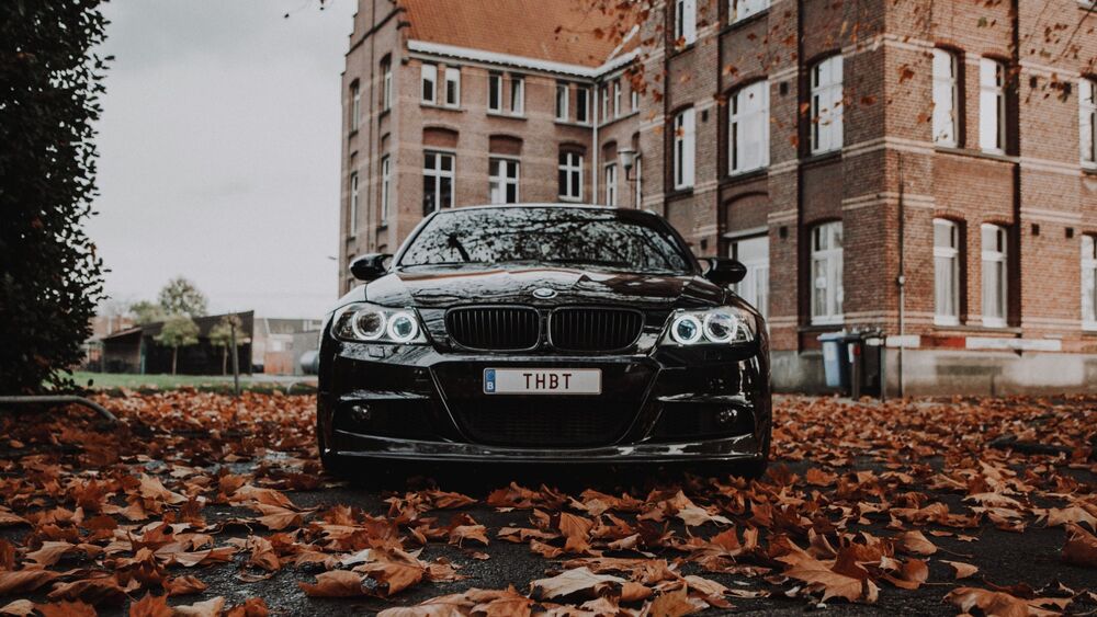 Обои для рабочего стола BMW E60 стоит у дома на желтых листьях