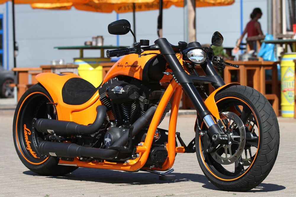 Обои для рабочего стола Желтый мотоцикл Harley Davidson стоит на улице возле кафе