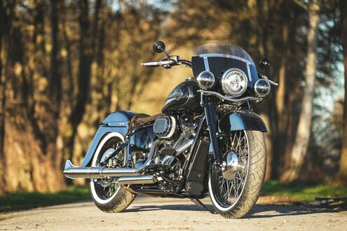 Обои на рабочий стол Черный мотоцикл Harley Davidson стоит на лесной дороге