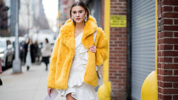 Обои на рабочий стол Стефани Гизингер / Stefanie Giesinger — немецкая модель в белом платье и желтой шубе с сумочкой на плече стоит на улице города