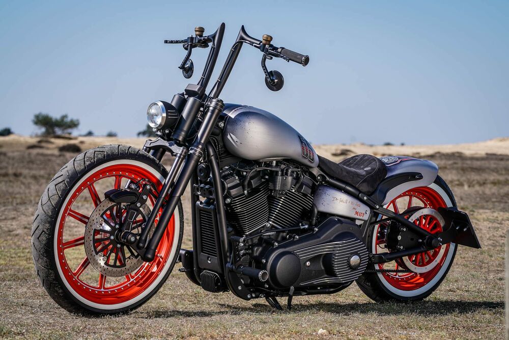 Обои для рабочего стола Серый Harley Davidson с красными колесами стоит посреди пустыни