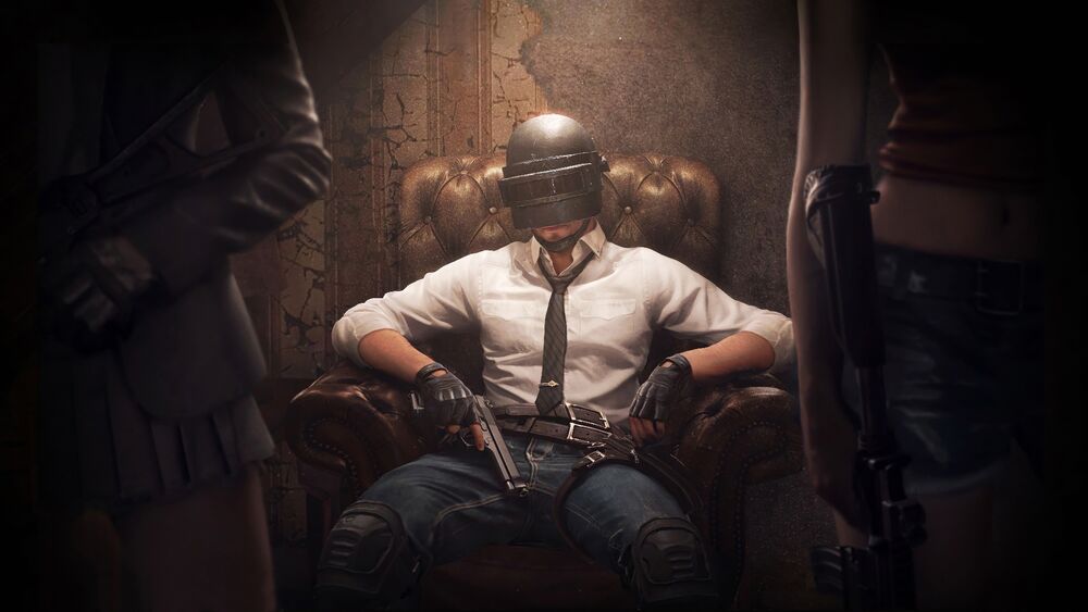 Обои для рабочего стола Мужчина из игры PUBG: BATTLEGROUNDS сидит в кресле за спиной девушек с оружием в руках