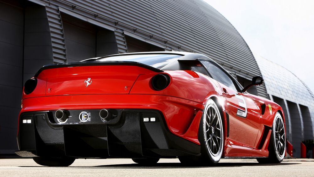 Обои для рабочего стола Красная Ferrari 599 сзади у ангаров