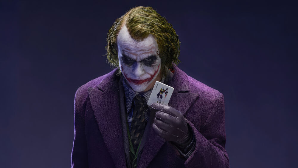 Обои для рабочего стола Джокер / Joker в фиолетовом пальто с картой джокера в руке из фильма Бэтмен: Темный рыцарь / Batman: The Dark Knight
