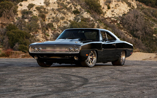 Обои на рабочий стол Черный Dodge Charger стоит на стоянке на фоне гор