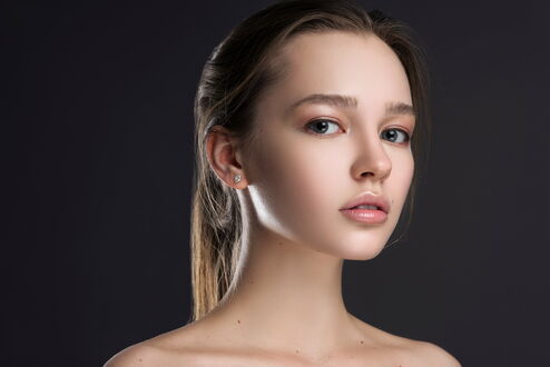 Обои на рабочий стол Портрет молодой девушки шатенка на сером фоне