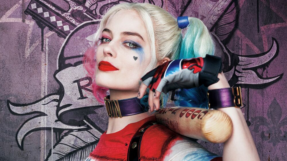 Обои для рабочего стола Харли Квинн / Harley Quinn с разноцветными хвостиками держит биту на фоне фиолетовой стены с граффити из вселенной DC Comics