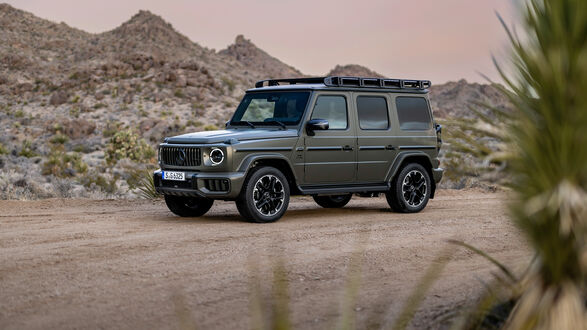 Обои на рабочий стол Серый внедорожник Mercedes-AMG G 63 2024 года на дороге в холмах