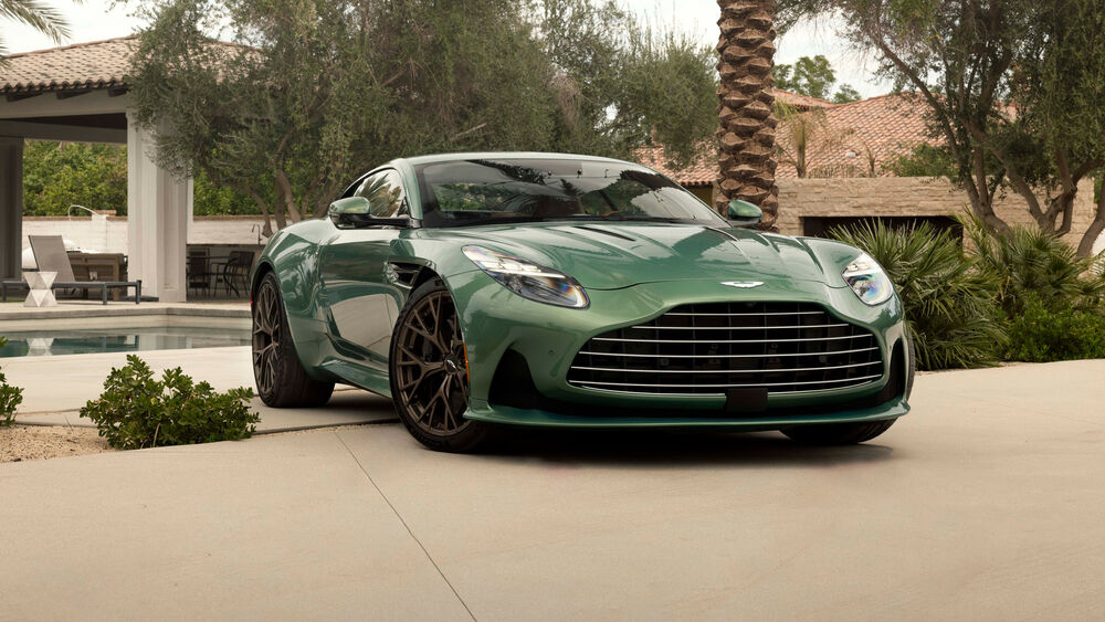 Обои для рабочего стола Автомобиль Aston Martin DBX707 стоит на парковке около бассейна на фоне частного дома в солнечный день