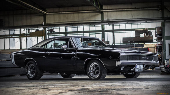 Обои на рабочий стол Dodge / Додж Charger / Чарджер черного цвета стоит в ангаре на фоне больших окон в дневное время