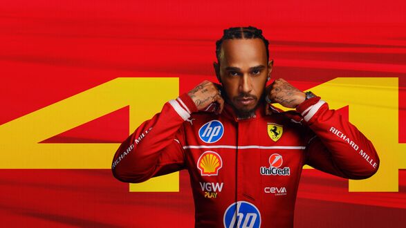 Обои на рабочий стол Льюис Хэмилтон / Lewis Hamilton в красном гоночном костюме на красном фоне с желтой цифрой 44