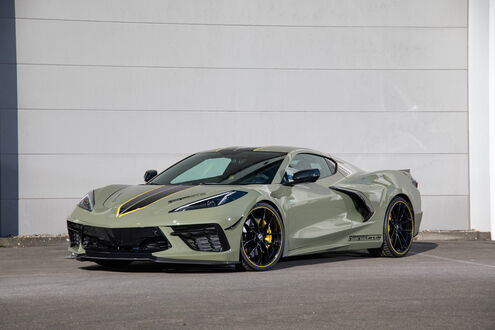 Обои на рабочий стол Chevrolet Corvette Stingray / Шевроле Корвет Стингрей оливково-зеленого цвета стоит на парковке на фоне светлой стены днем в солнечную погоду