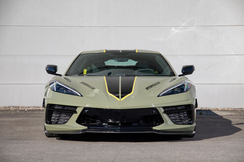 Обои на рабочий стол Chevrolet Corvette Stingray / Шевроле Корвет Стингрей оливкового цвета стоит на светлой парковке днем в солнечный день на фоне белой стены
