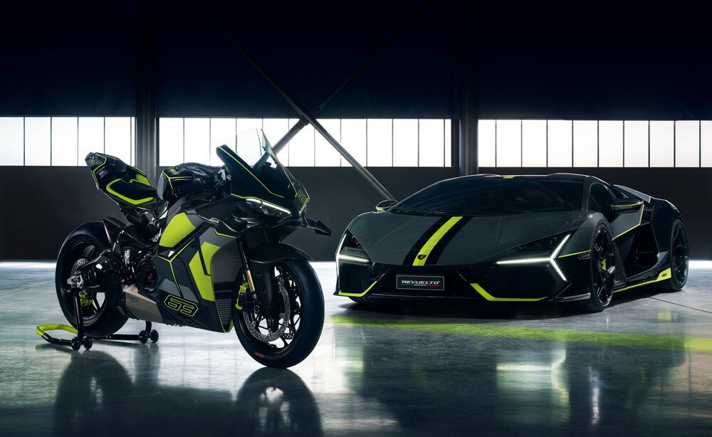 Обои для рабочего стола Мотоцикл Ducati / Дукати и автомобиль Lamborghini Revuelto / Ламборджини Ревуэльто стоят в ангаре на фоне больших окон