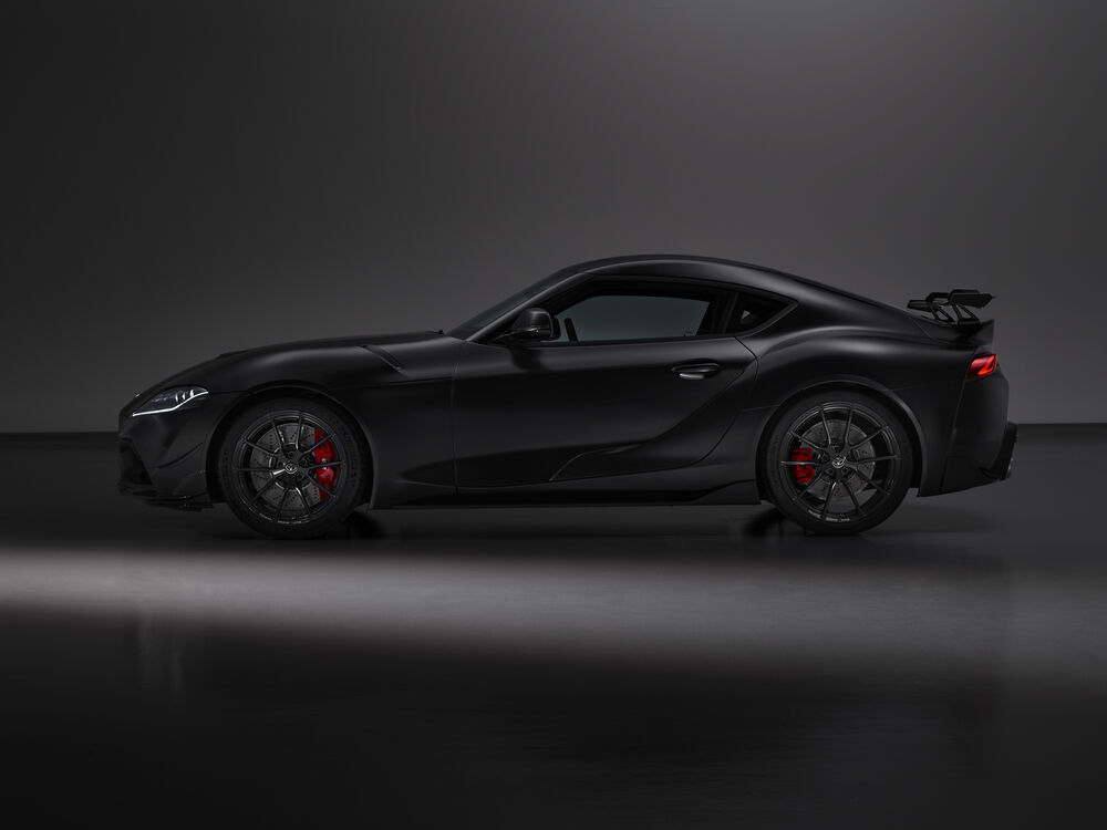 Обои для рабочего стола Toyota GR Supra A90 Final Edition 2025 черного цвета стоит в темном помещении на гладком полу вид сбоку