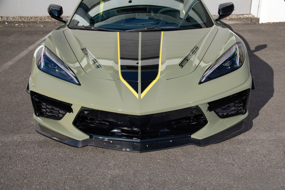 Обои для рабочего стола Chevrolet Corvette Stingray / Шевроле Корвет Стингрей стоит на парковке в солнечный день на фоне серого здания