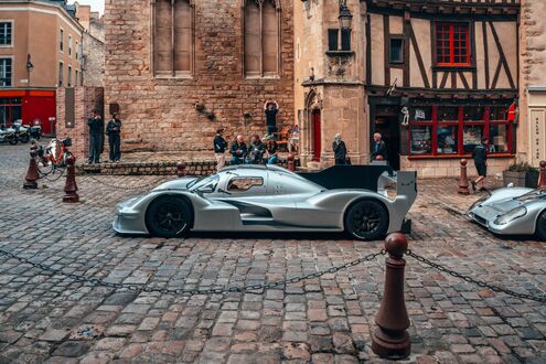 Обои на рабочий стол Серебристый прототип гоночного автомобиля Porsche на улице старого города