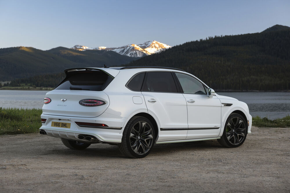 Обои для рабочего стола Автомобиль Bentley Bentayga белого цвета стоит на берегу озера на фоне гор в солнечный день