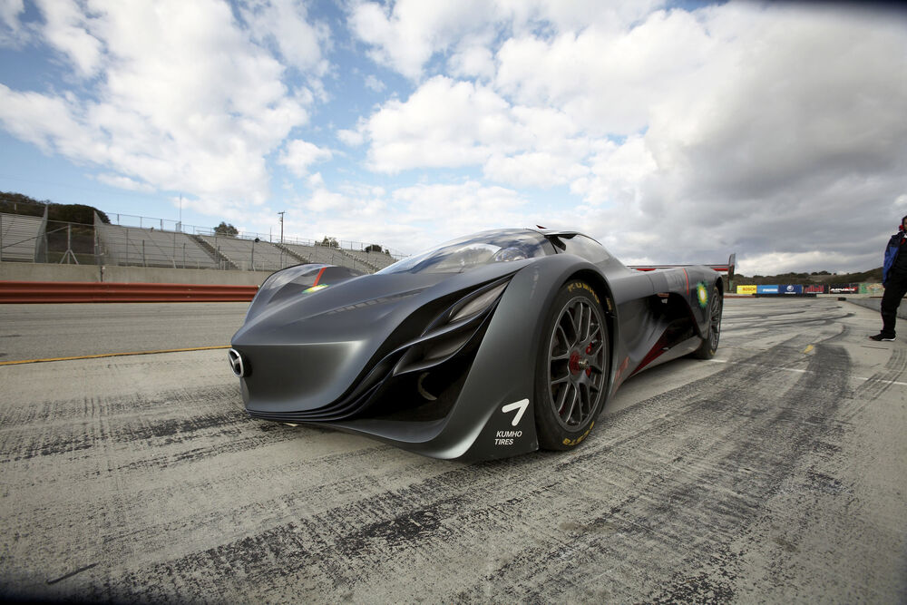 Обои для рабочего стола Автомобиль Mazda Furai стоит на гоночной трассе в солнечный день на фоне пустых трибун