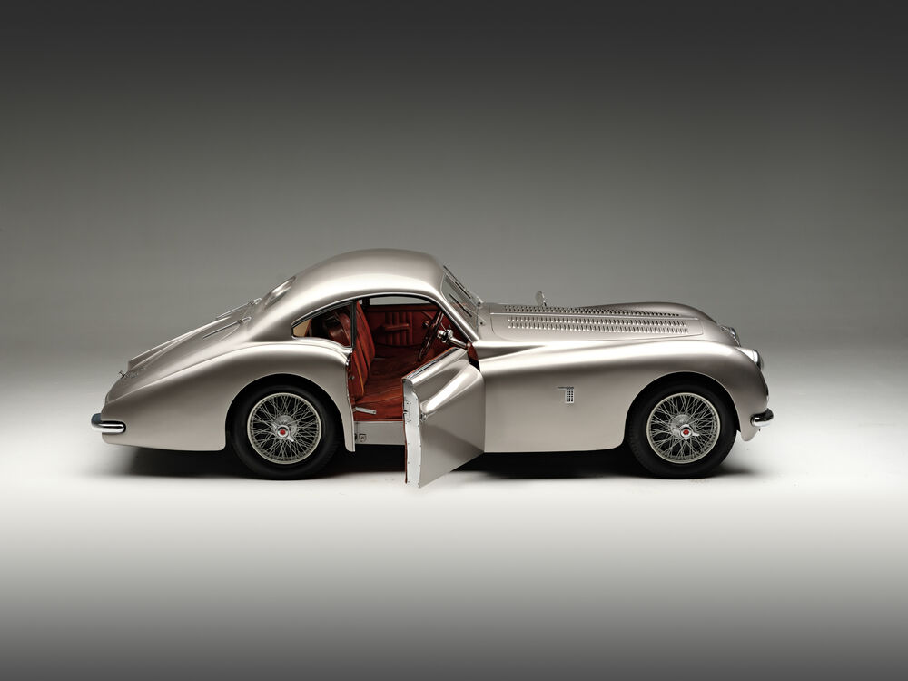 Обои для рабочего стола Автомобиль Talbot-Lago / Тальбо-Лаго T26 GS Coupe серебристого цвета с открытой дверью стоит на светлом фоне в студии