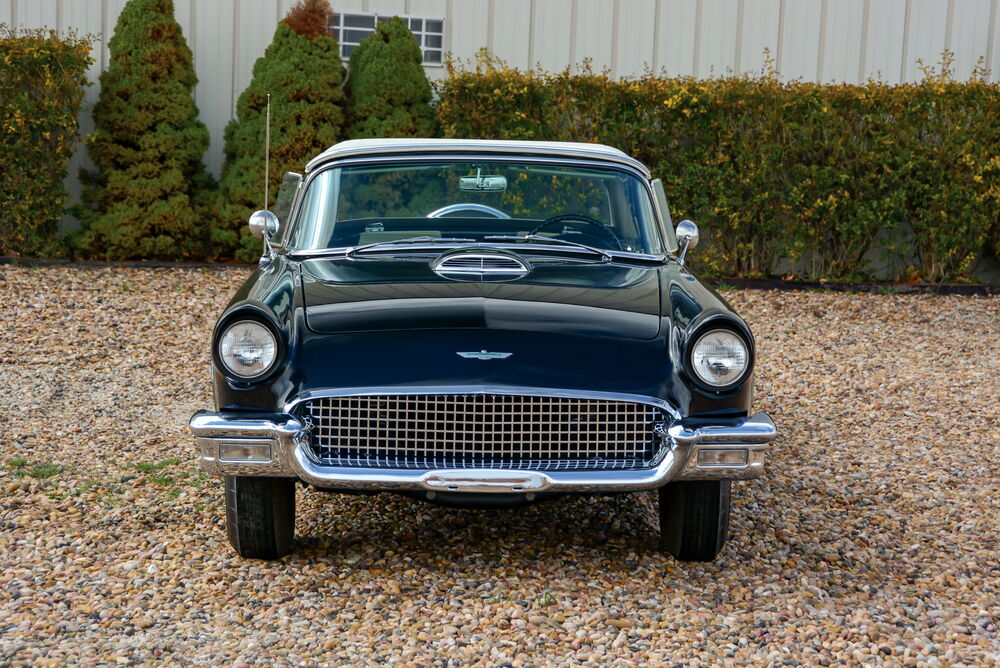 Обои для рабочего стола Автомобиль Ford / Форд Thunderbird черного цвета стоит на гравийной площадке на фоне кустарников