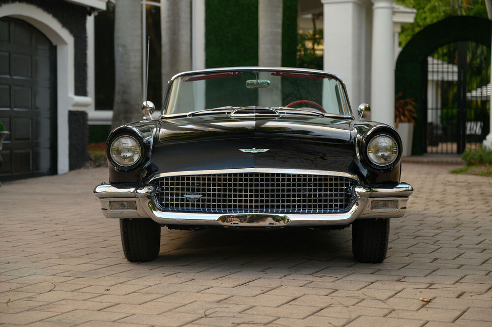 Обои для рабочего стола Автомобиль Ford / Форд Thunderbird черного цвета стоит на бежевой брусчатке на фоне дома вид спереди