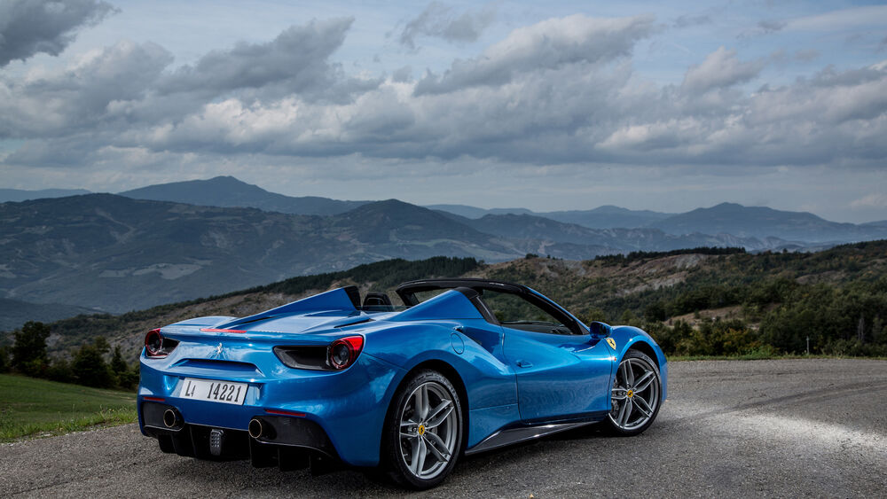 Обои для рабочего стола Ferrari 488 на дороге на фоне гор вид сзади