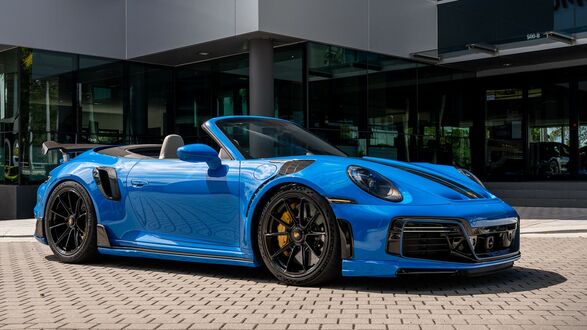 Обои на рабочий стол Синий Porsche 911 Turbo S Cabriolet стоит около автосалона
