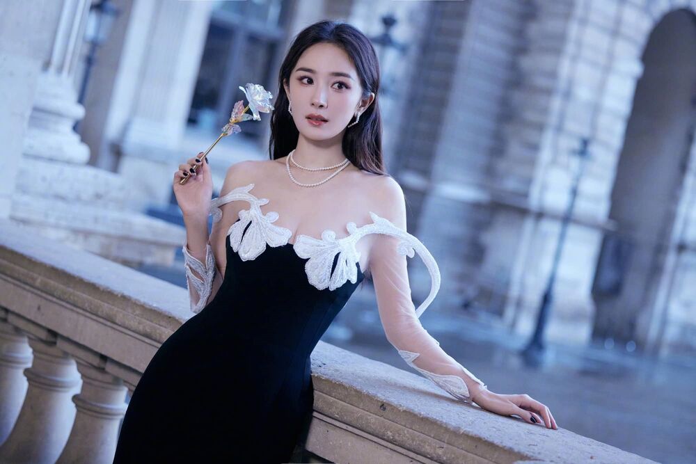 Обои для рабочего стола Китайская актриса Ян Ми / Yang Mi в черном платье с искуственной розой у парапета, для показа бренда Christian Louboutin