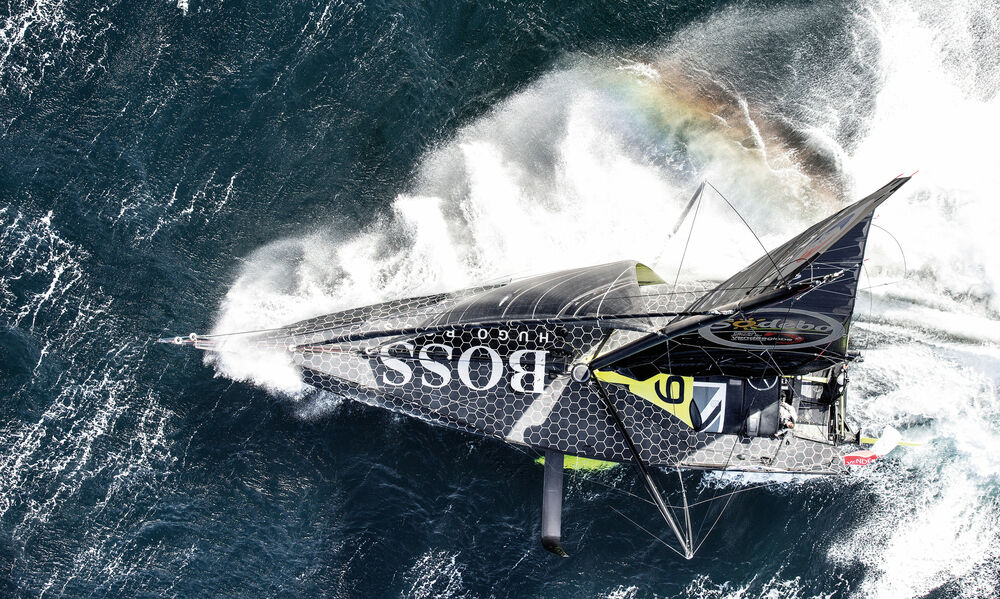 Обои для рабочего стола Парусная яхта Hugo Boss движется по водной глади, оставляя за собой пенные следы вид сверху