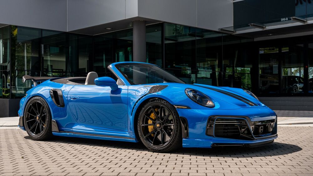 Обои для рабочего стола Синий Porsche 911 Turbo S Cabriolet стоит около автосалона