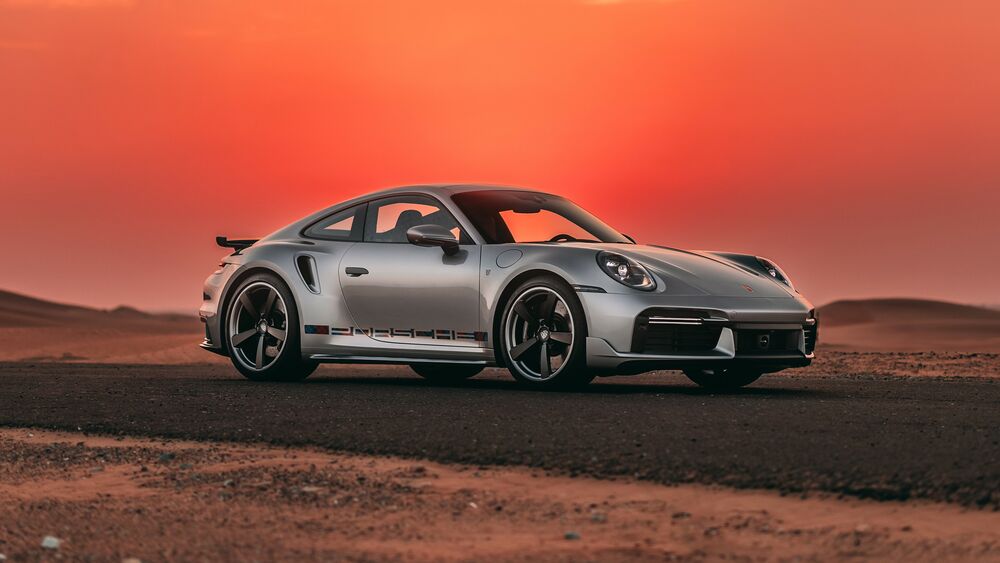 Обои для рабочего стола Серый Porsche 911 Turbo на фоне красного неба