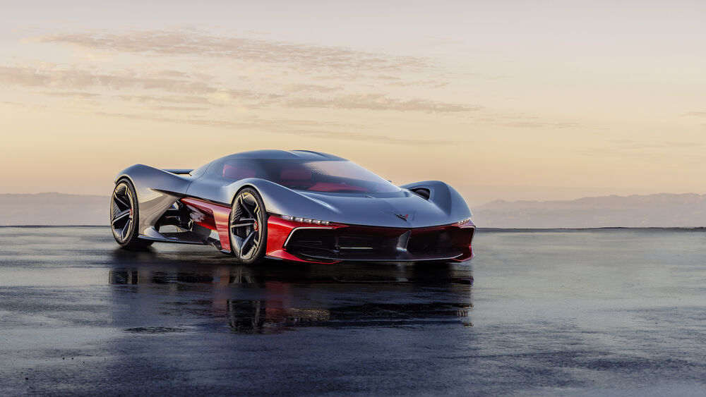 Обои для рабочего стола Концепт Chevrolet Corvette стоит на мокром асфальте на фоне гор на закате
