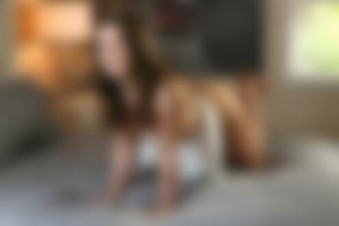 Обои на рабочий стол Модель Paige Owens в белой юбке и в трусиках топлес стоит на четвереньках на кровати в комнате