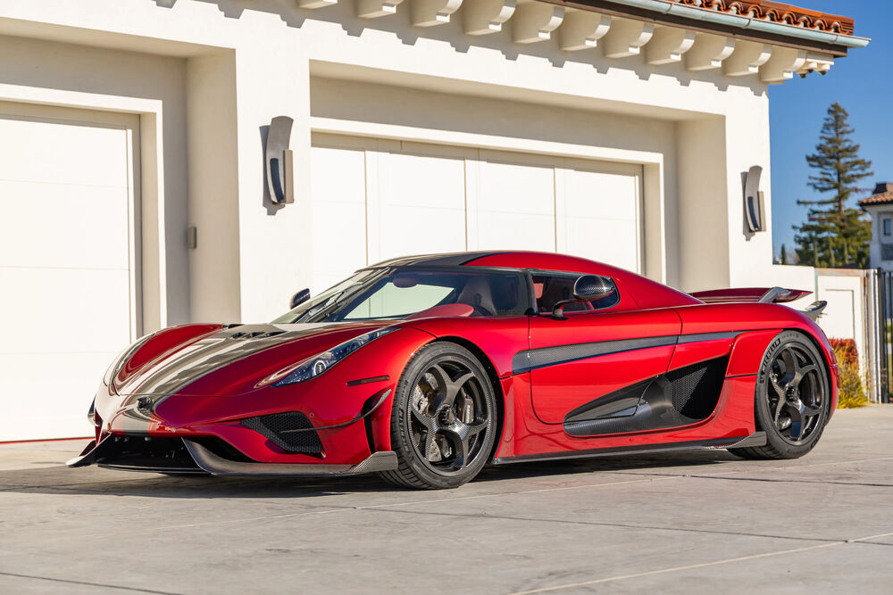Обои для рабочего стола Суперкар красного цвета Koenigsegg Regera на фоне здания