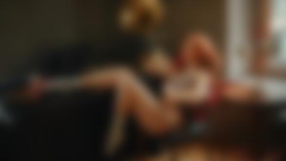 Обои на рабочий стол Модель Ксения с ожерельем на шее и в нижнем белье сидит на кресле в комнате, положив ногу на стол