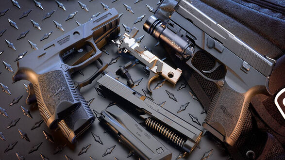 Обои на рабочий стол Пистолеты Sig Sauer P250 на темной металлической поверхности