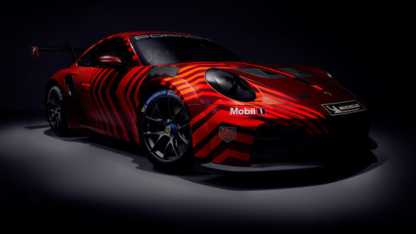 Обои на рабочий стол Красный гоночный автомобиль Порше / Porsche с черными и оранжевыми полосами и логотипами (PORSCHE, Mobil 1, TAG Heuer, MICHELIN) на боку и капоте, на черном фоне