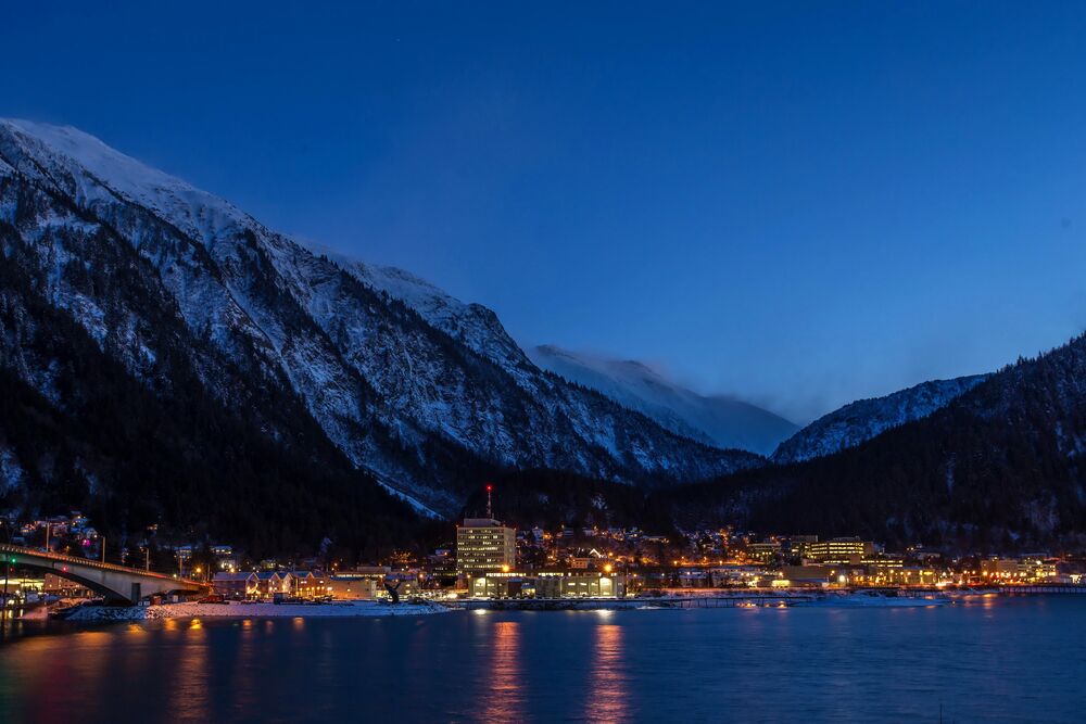 Обои для рабочего стола Джуно / Juneau, США / USA, огни города отражаются в темной воде залива, мост пересекает канал, на фоне заснеженных гор и темного неба