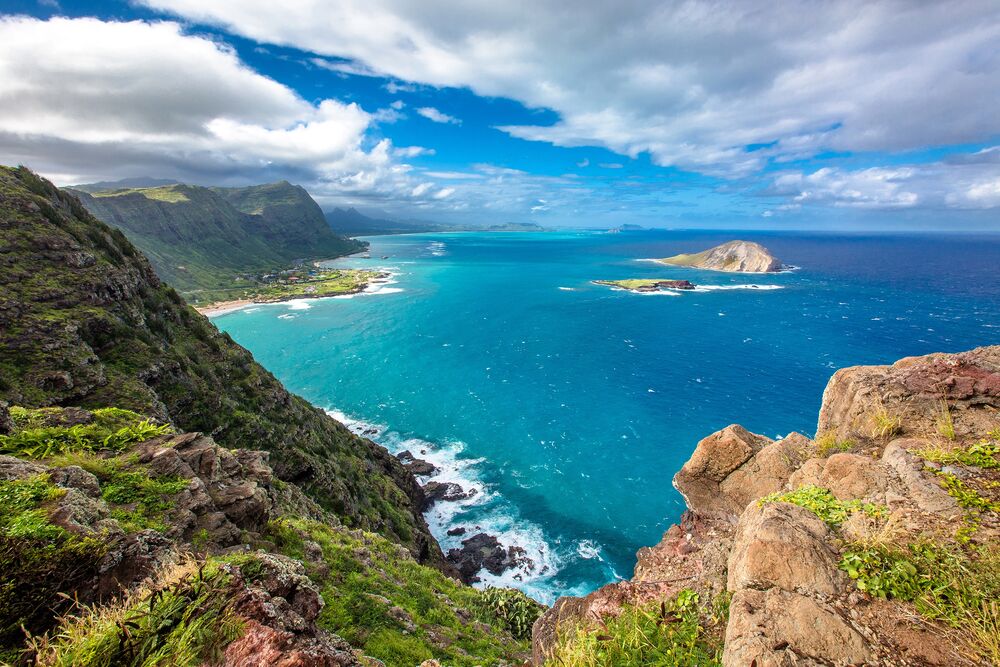 Обои для рабочего стола Гавайи / Hawaii, США / USA, скалистый берег с зеленой растительностью, на фоне бирюзового океана с островами и облачным небом