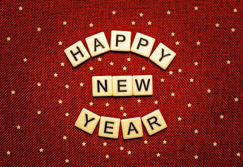 Обои на рабочий стол Белые квадратные плитки с черными буквами, (Happy New Year), на красном фоне, с множеством мелких белых звезд