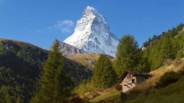 Обои на рабочий стол Гора Маттерхорн / Matterhorn, Швейцария / Switzerland, заснеженная, с хижиной и деревьями на склоне, на фоне неба