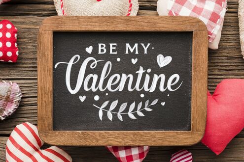 Обои на рабочий стол Деревянная доска с надписью (BE MY Valentine) и рисунками сердец, окруженная тканевыми сердцами, на фоне деревянной поверхности