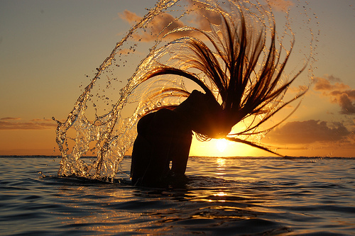 Фото Девушка в море напротив красивого заката