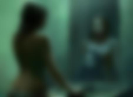 Фото Девушка смотрит в зеркало и в отражении видит лицо девочки рядом