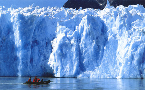 Фото Антарктида.Лодка с людьми проплывает мимо величественных айсбергов