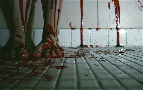 Фото Залитые кровью ноги стоят на окровавленном кафеле